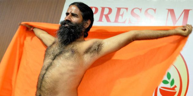 Indian Yoga guru Baba Ramdev stretches after addressing a press conference in Bangalore on March 18, 2016, ahead of a five day yoga camp. / AFP / Manjunath Kiran (Photo credit should read MANJUNATH KIRAN/AFP/Getty Images)