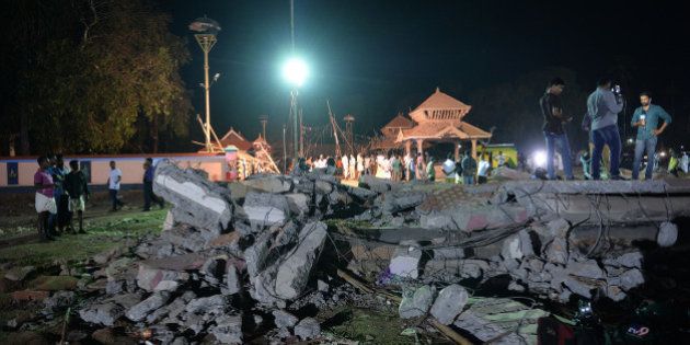 Onlookers and medias stand amidst the debris in the aftermath of the deadly fire explosion that rocked the Hindu Goddess, Puttingal Devi Temple in Paravur, 60kms North-West of Thiruvananthapuram in Kerala on the late evening of April 10, 2016. More than 100 people have died and 350 injured when fireworks meant to be lit for festivities caught fire and exploded near the temple where thousands of people had gathered to witness the extravanganza on the early hours of April 10. / AFP / MANJUNATH KIRAN (Photo credit should read MANJUNATH KIRAN/AFP/Getty Images)