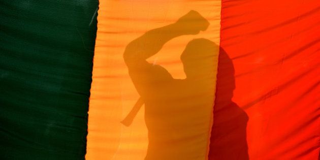 An Indian gay-rights activist gestures behind a flag during a protest against the Supreme Court ruling reinstating a ban on gay sex in Bangalore on December 11, 2013. India's Supreme Court reinstated a colonial-era ban on gay sex on that could see homosexuals jailed for up to ten years in a major setback for rights campaigners in the world's biggest democracy. AFP PHOTO/Manjunath KIRAN (Photo credit should read Manjunath Kiran/AFP/Getty Images)