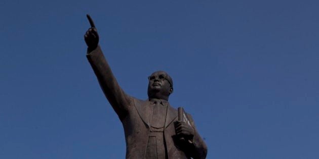 An Indian worker cleans a portrait of B.R. Ambedkar which stands inside the premises of the Indian Parliament in New Delhi, India, Friday, Dec. 5, 2014. Ambedkar, an untouchable, or dalit, and a prominent Indian freedom fighter, was the chief architect of the Indian Constitution, which outlawed discrimination based on caste. (AP Photo/Saurabh Das)