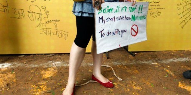 A woman holds a placard as messages written by people are seen in the background at the Delhi