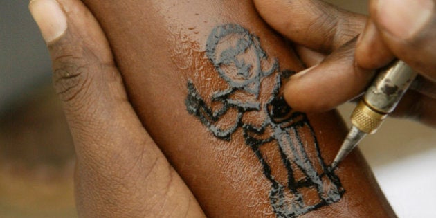 A man gets a tatoo of Bhim Rao Ambedkar, near his memorial in Mumbai, India, Wednesday, Dec. 5, 2007.Ambedkar, an untouchable, or dalit, and a prominent Indian freedom fighter, was the chief architect of the Indian Constitution, which outlawed discrimination based on caste. Hundreds of thousands of low-caste Indians are expected to pay homage at his memorial Thursday, on his 51st death anniversary. (AP Photo/Gautam Singh)