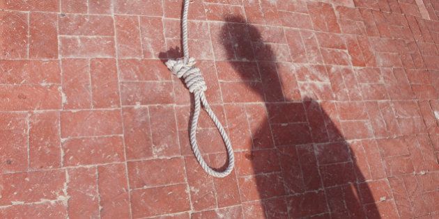 The shadow of a prisoner waits by the noose for a death penalty hanging.
