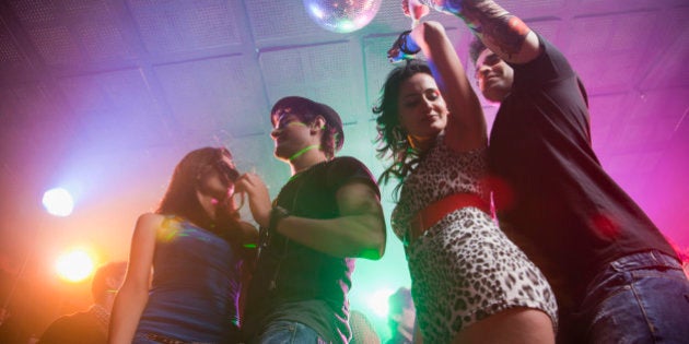 Two young couples on nightclub dance floor