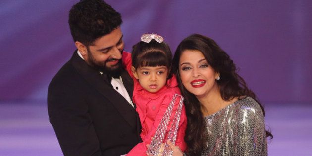 Former Miss World Aishwarya Rai, centre speaks on stage with husband Abhishek Bachchan and daughter Aaradhya Bachchan, during the Miss World 2014 final, on stage at the Excel centre in east London, Sunday, Dec. 14, 2014. (Photo by Joel Ryan/Invision/AP)