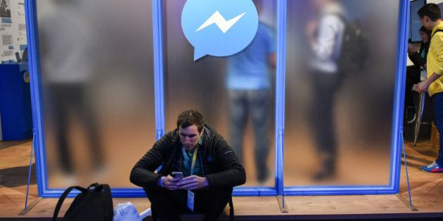An attendee sits in front of a messenger logo during the Facebook F8 Developers Conference in San Francisco, California, U.S., on Tuesday, April 12, 2016. Facebook Inc. Chief Executive Officer Mark Zuckerberg outlined a 10-year plan to alter the way people interact with each other and the brands that keep advertising dollars rolling at the worlds largest social network. Photographer: Michael Short/Bloomberg via Getty Images