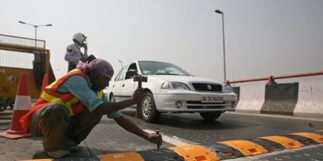 NEW DELHI, INDIA ï¿½ AUGUST 1: Workers install a metallic speed breaker on the Dwarka flyover after 9 people lost their lives on the flyover due to the faulty design of the flyover in New Delhi on Saturday, August 1, 2009. (Photo by Shekhar Yadav/ India Today Group/ Getty Images)
