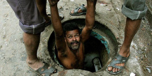 An Indian labourer is lowered to clean a sewage hole in the eastern Indian city of Kolkata December 16, 2005. Acceleration in economic growth has made India amongst the 10 fastest growing developing countries. Yet, about 30 percent of India's more than one billion people live below the official poverty line of 2,100-2,400 calories a day. REUTERS/Parth Sanyal