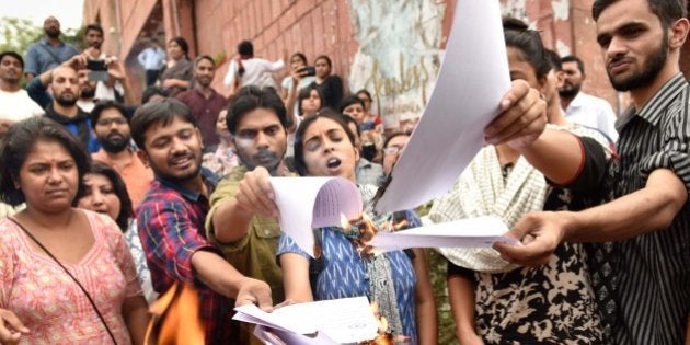 NEW DELHI , INDIA - APRIL 26: JNUSU President Kanhaiya Kumar with Umar Khalid, Anirban Bhattacharya and Shehla Rashid Shora burning copies of the report in front of the administrative block, on April 26, 2016 in New Delhi , India. JNU has suspended students Umar Khalid, Anirban Bhattacharya and Shehla Rashid Shora while slapping a fine of Rs. 10,000 on Students' Union President Kanhaiya Kumar. JNU students' union has decided to go on an indefinite hunger strike starting Wednesday to protest the action taken against its President Kanhaiya Kumar. Kanhaiya, Umar Khalid and Anirban Bhattacharya were arrested on charges of sedition in February in connection with an event against hanging of Parliament attack convict Afzal Guru. (Photo by Vipin Kumar/Hindustan Times via Getty Images)