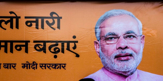 A pedestrian walks past a billboard for the Bharatiya Janta Party (BJP) picturing its prime ministerial candidate Narenda Modi as the third phase of voting for national elections commences in New Delhi, India, on Thursday, April 10, 2014. About 13 million voters spread across seven constituencies in Delhi will elect representatives along with voters in parts of Uttar Pradesh, Haryana, Maharashtra, Orissa and Kerala. Ninety-two seats will be decided today, although results from all 543 constituencies will be announced together on May 16. Photographer: Prashanth Vishwanathan/Bloomberg via Getty Images