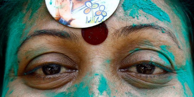 A supporter of Mamata Banerjee, chief minister of the eastern Indian state of West Bengal and Trinamool Congress (TMC) chief, wears her picture during the celebrations after learning of the initial poll results in Kolkata May 16, 2014. Celebrations were in full swing on Friday in the headquarters of those winning regional parties of India, for which early trends of the poll results showed victory. The ruling Trinamool Congress Party (TMC) in India's eastern West Bengal is confident of bagging the lion's share of seats and a clear sweep in the face of a challenge by the Left Front and the Congress. REUTERS/Rupak De Chowdhuri (INDIA - Tags: POLITICS ELECTIONS)