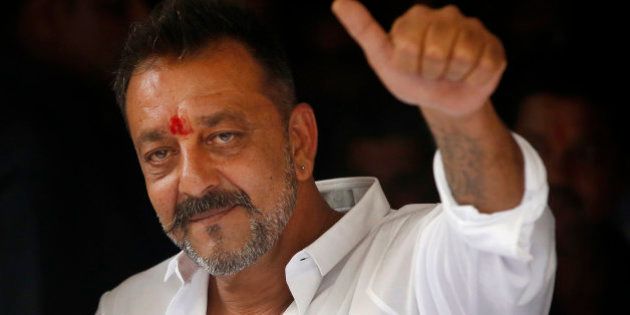 Bollywood actor Sanjay Dutt shows a thumbs up sign after arriving at his residence in Mumbai, India, Thursday, Feb. 25, 2016. Actor Dutt walked free Thursday after completing his five-year prison sentence for illegal weapons possession in a case linked to the 1993 terror attack in India's financial capital Mumbai. (AP Photo/Rajanish Kakade)