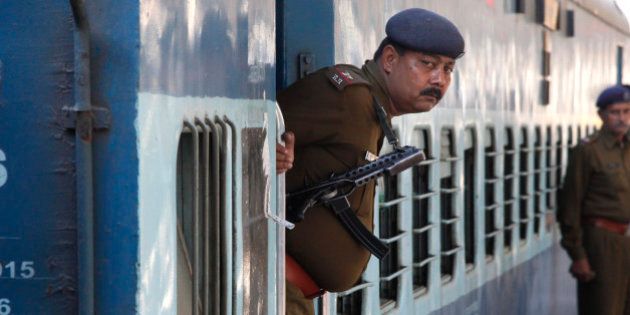 A Railway Police personnel peeps out from the door of a special passenger train at a railway station in Chandigarh, India, February 22, 2016. REUTERS/Ajay Verma
