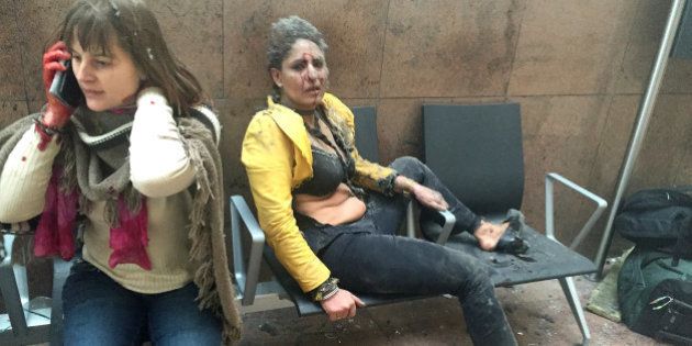 BRUSSELS, BELGIUM - MARCH 22: Flight attendant Nidhi Chaphekar (R) reacts in the moments following a suicide bombing at Brussels Zaventem airport on March 22, 2016 in Brussels, Belgium. Georgian journalist Ketevan Kardava, special correspondent for the Georgian Public Broadcaster, was travelling to Geneva when the attack took place, she was knocked to the floor and began to take photographs in the moments that followed. At least 31 people were killed and more than 260 injured in a twin suicide blast at Zaventem Airport and a further bomb attack at Maelbeek Metro Station. Two brothers are thought to have carried out the attacks and a manhunt is underway for a third suspect. (Photo by Ketevan Kardava/Getty Images)