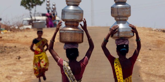 Indian women walk home after collecting drinking water from a well at Mengal Pada in Thane district in Maharashtra state, India, Wednesday, May 4, 2016. Much of India is reeling under a weekslong heat wave and severe drought conditions that have decimated crops, killed livestock and left at least 330 million Indians without enough water for their daily needs. (AP Photo/ Rajanish Kakade )