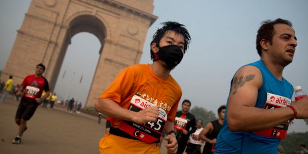 A participant wears a mask as he runs past the India Gate memorial during Delhi Half Marathon in New Delhi, India, Sunday, Nov. 29, 2015.The tens of thousands of people who participated in Sundayâs half marathon in Indiaâs capital had more than just running 21 kilometers (13 miles) through New Delhiâs streets on a misty, chilly morning to deal with. They also had to overcome the cityâs unparalleled air pollution. (AP Photo /Tsering Topgyal)