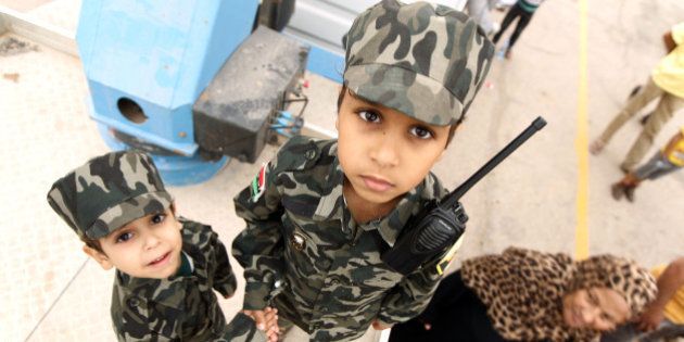 Libyan children dressed in military fatigues attend a demonstration in the eastern coastal city of Benghazi calling for military forces to re-capture the southern city of Sirte from the Islamic State (IS) group without foreign intervention on May 6, 2016.The head of Libya's unity government announced plans the previous month for a concerted campaign to drive the Islamic State group out of the North African country, but without foreign intervention. The unity government fears that separate operations in Sirte could spark clashes between the multitude of different fighting forces in Libya and play into the jihadists' hands. / AFP / ABDULLAH DOMA (Photo credit should read ABDULLAH DOMA/AFP/Getty Images)