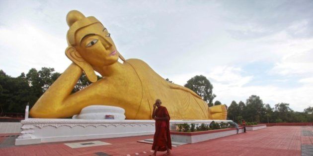 A Bangladeshi Buddhist monk walks in front of a Buddha statue at one of the rebuilt Buddhist temples in Ramu, in the coastal district of Cox's Bazar, Bangladesh, Wednesday, Sept. 11, 2013. The Bangladesh government has rebuilt a total of 19 Buddhist temple that were torched an overnight attack by Muslims last year. Buddhists make up less than 1 percent of Muslim-majority Bangladesh's 150 million people. (AP Photo/A.M.Ahad)