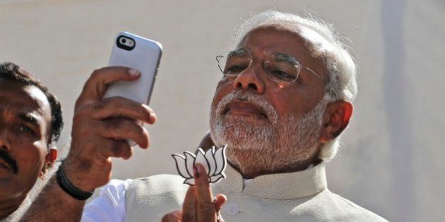FILE- In this April 30, 2014 file photograph, India's main opposition Bharatiya Janata Partyâs prime ministerial candidate Narendra Modi holds his partyâs symbol and looks into his phone after casting his vote in Ahmadabad, India. In the Twitterverse ruled by President Barack Obama, India's new Prime Minister Modi may soon overtake the White House on Twitter.An analysis of Twitter accounts â showing the emphasis some governments put on digital diplomacy as a 21st-century tool for statecraft â projects Modi, already the fifth most-followed world leader on Twitter with 4.95 million followers, will soon overtake the White House's 4.97 million.(AP Photo/Ajit Solanki, file)