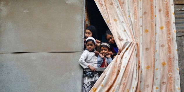 Muslim children peep through an opening of their house to watch a religious procession to mark Eid-e-Milad-ul-Nabi, or birthday celebrations of Prophet Mohammad, in the old quarters of Delhi January 14, 2014. REUTERS/Anindito Mukherjee (INDIA - Tags: RELIGION SOCIETY ANNIVERSARY)