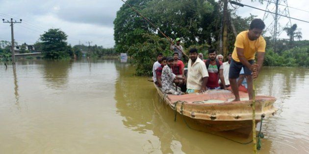 Sri Lankan residents travel by boat through the floodwaters in Pugoda, about 35 kms from capital Colombo on May 17, 2016.Heavy rains claimed three more lives in Sri Lanka on May 17, raising weather-related deaths to 11 as more than 50,000 families were driven out of their flooded homes, officials said / AFP / ISHARA S.KODIKARA (Photo credit should read ISHARA S.KODIKARA/AFP/Getty Images)