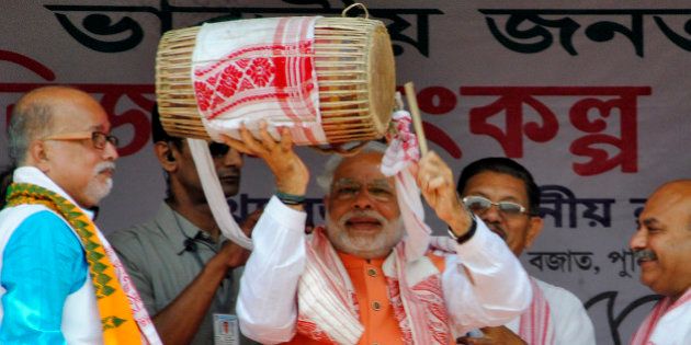Hindu nationalist Narendra Modi (C), the prime ministerial candidate for India's main opposition Bharatiya Janata Party (BJP), plays a dhol, an Indian musical instrument, during an election campaign rally in Mangaldoi in the northeastern Indian state of Assam April 19, 2014. Around 815 million people have registered to vote in the world's biggest election - a number exceeding the population of Europe and a world record - and results of the mammoth exercise, which concludes on May 12, are due on May 16. REUTERS/Stringer (INDIA - Tags: POLITICS ELECTIONS)