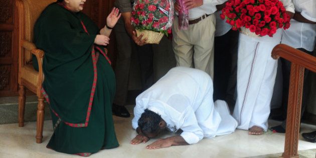 A party cadre prostrates himself at the feet of All India Anna Dravida Munnetra Kazhagam(AIADMK) leader Jayalalithaa Jayaram as she gestures at her residence in Chennai on May 19, 2016.The makeup of India's next government could lie in the hands of a trio of women who command a massive following in their regional heartlands, including a populist former movie star known as 'Mother' to supporters. / AFP / ARUN SANKAR (Photo credit should read ARUN SANKAR/AFP/Getty Images)
