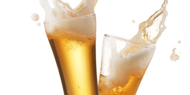 two glasses of beer toasting creating splash
