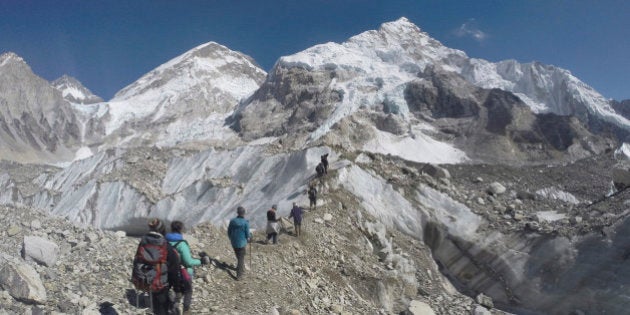 In this Monday, Feb. 22, 2016 photo, international trekkers pass through a glacier at the Mount Everest base camp, Nepal. Nepal has extended the permits of climbers who were unable to climb Mount Everest last year due to an earthquake-triggered avalanche that killed 19 people at a base camp in hopes of bringing back western climbers to the world's highest peak. Mountaineering Department official Gyanendra Shrestha said Tuesday, March 1 that the climbers can attempt to climb the world's tallest peak this year or next year without paying new fees. (AP Photo/Tashi Sherpa)