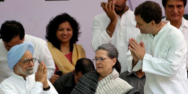 Former prime minister Manmohan Singh (L) is greeted by India's main opposition Congress party's vice-president Rahul Gandhi as the party's President Sonia Gandhi (C) looks on before what the party calls