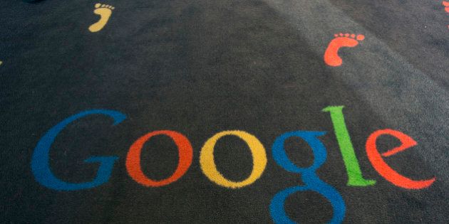 FILE - This Tuesday, Dec. 10, 2013 file photo shows the Google logo printed on a carpet during the inauguration of the new Google cultural institute in Paris, France. French police have raided Google's Paris offices as part of an investigation into