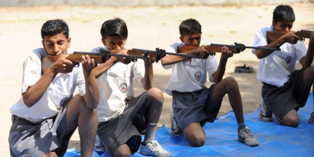 Volunteers of Bajrang Dal participate in the air rifle training session at a youth camp on the outskirts of Ahmedabad in the early morning of May 17, 2012. Some 168 students, 18 instructors and 15 organisers are participating in a Bajrang Dal Basic Youth Camp from May 13 - 20. Bajrang Dal, a hardline Hindu organization in India, is the youth wing of the Vishwa Hindu Parishad (VHP) and is based on the ideology of Hindutva. Apart from safeguarding 'holy cows', other goals include protecting India's Hindu identity from the perceived dangers of communalism, Muslim demographic growth and Christian conversion. AFP PHOTO / Sam PANTHAKY (Photo credit should read SAM PANTHAKY/AFP/GettyImages)