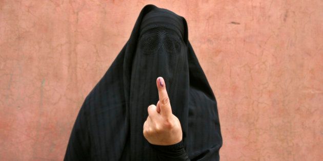 A veiled Muslim woman shows her ink-marked finger after voting outside a polling station in Doda district, north of Jammu, April 17, 2014. Around 815 million people have registered to vote in the world's biggest election - a number exceeding the population of Europe and a world record - and results of the mammoth exercise, which concludes on May 12, are due on May 16. REUTERS/Mukesh Gupta (INDIAN-ADMINISTERED KASHMIR - Tags: POLITICS ELECTIONS)