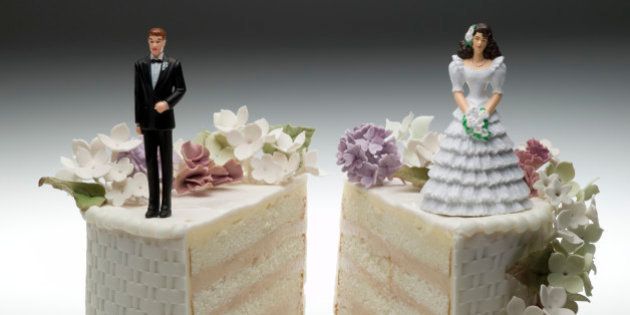 Bride and groom figurines standing on two separated slices of wedding cake