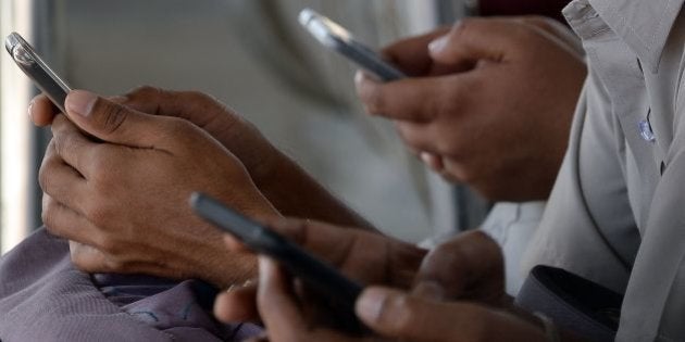 Indian consumers check their mobile telephones at a free Wi-Fi Internet zone in Mumbai on February 23, 2016. India is the world's second-largest mobile market and notched up its billionth mobile phone subscriber in October, according to the country's telecoms regulator. But in poorer Indian states such as Bihar, 'teledensity' -- the penetration of telephone connections for every hundred people -- is as low as 54 percent, with a stark urban-rural divide. AFP PHOTO/ INDRANIL MUKHERJEE / AFP / INDRANIL MUKHERJEE (Photo credit should read INDRANIL MUKHERJEE/AFP/Getty Images)