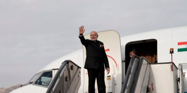 Indian Prime Minister Narendra Modi gives a goodbye as he boards his plane at Kabul International Airport in Kabul, Afghanistan, Friday, Dec. 25, 2015, India donated four Mi-25 attack helicopters to Afghanistan Air Force. (AP Photo/Rahmat Gul)