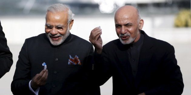 India's Prime Minister Narendra Modi (L) and Afghan president Ashraf Ghani hold sweets as they inaugurate Afghanistan's new parliament building, which was built with the Indian government's financial assistance, in Kabul, Afghanistan December 25, 2015. REUTERS/Omar Sobhani