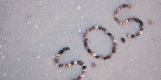 S.O.S written on the beach with stones