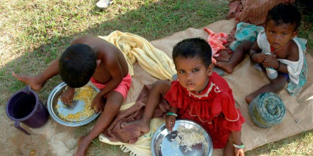 Homeless children eat food at a slum area on the outskirts of Agartala, capital of India's northeastern state of Tripura June 22, 2007. REUTERS/Jayanta Dey (INDIA)