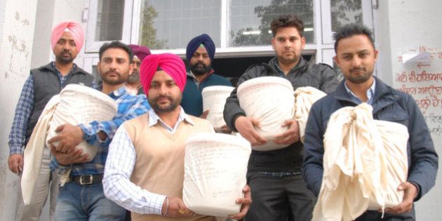 AMRITSAR, INDIA - FEBRUARY 26: Punjab Police Narcotics Department officials carrying 50 Kgs of heroin recovered from three smugglers coming out from court on February 26, 2015 in Amritsar, India. The state police chief said that after controlling the local availability of drugs and neutralising internal distribution network, Punjab Police is now focusing on plugging supply lines from across the international border. (Photo by Sameer Sehgal/Hindustan Times via Getty Images)