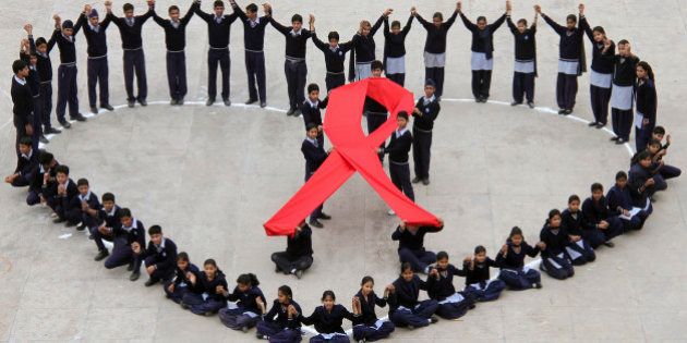 Students make a formation in the shape of a heart and a red ribbon during a HIV/AIDS awareness campaign on Valentine's Day in the northern Indian city of Chandigarh February 14, 2012. REUTERS/Ajay Verma (INDIA - Tags: TPX IMAGES OF THE DAY SOCIETY HEALTH)
