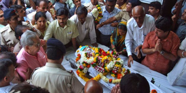 In this Tuesday, Aug. 20, 2013 photo, people pay last respects to anti-superstition activist Narendra Dabholkar who was killed in Pune, India. Police are searching for the two motorcycle-riding attackers, who in daylight gunned down the 67-year-old activist who crusaded against superstition, black magic and unholy Hindu godmen. (AP Photo/Nitin Lawate)