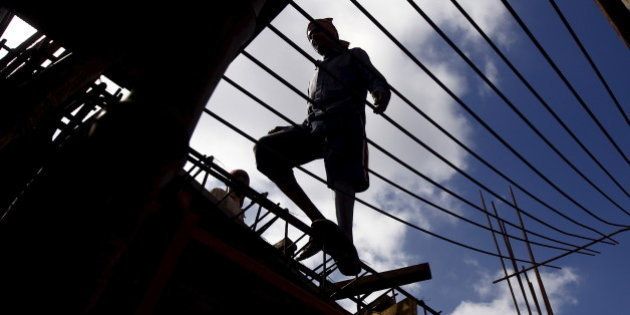 A labourer walks on an iron frame at the construction site of a residential complex on the outskirts of Kolkata, India, November 2, 2015. India's infrastructure output grew at its fastest pace in four months to 3.2 percent in September from a year ago, mainly driven by higher production of electricity and fertilisers, government data showed on Monday. REUTERS/Rupak De Chowdhuri