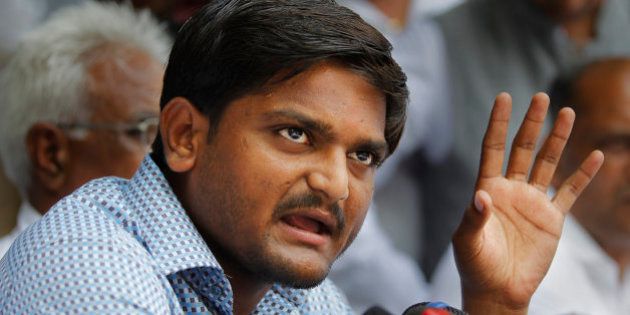 Hardik Patel, center, 22-year-old firebrand leader of Patidar Andolan Samiti addresses a press conference in New Delhi, India, Sunday, Aug. 30, 2015. Patel is leading an agitation for members of Gujarat state Patel community demanding government benefits for them under the Other Backward Class (OBC) quota. (AP Photo/Altaf Qadri)