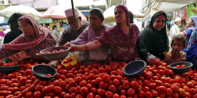 Local residents buy tomatoes from a roadside vegetable market in Ahmedabad, India, August 7, 2015. Entrenched expectations of high inflation in India are feeding into higher wages and other prices, which could tie India's central bank governor Raghuram Rajan's hands even as he faces growing pressure to cut interest rates for a fourth time this year to help a patchy economy. Picture taken August 7. REUTERS/Amit Dave