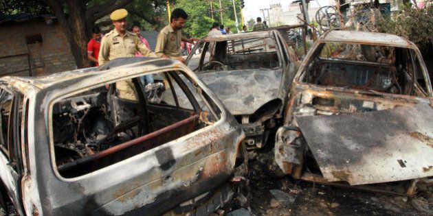 JAMMU, INDIA - JUNE 15: Jammu and Kashmir police men inspect the vehicles burnt by the protesters as city witnessed a near total bandh in protest against alleged desecration of a temple here last night on June 15, 2016 in Jammu, India. According to the news reports, mobile internet services were suspended in all 10 districts of Jammu region after the protests against the desecration of an ancient temple of Lord Shiva by youth of the other community whom was blamed for smashing the window panes and doors of a temple. (Photo by Nitin Kanotra/Hindustan Times via Getty Images)