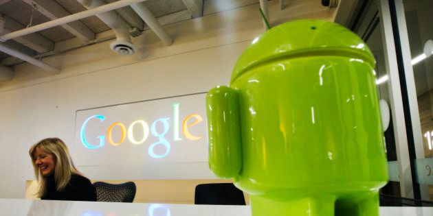 A Google Android figurine sits on the welcome desk as employee Tracy McNeilly smiles at the new Google office in Toronto, November 13, 2012. REUTERS/Mark Blinch (CANADA - Tags: BUSINESS LOGO SCIENCE TECHNOLOGY TELECOMS)