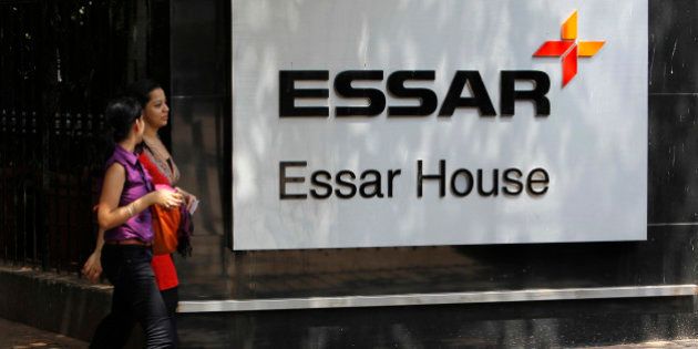 Employees walk past an Essar Group logo outside their headquarters in Mumbai May 20, 2013. India's Economic Times newspaper said the Essar Group conglomerate would sign a financial agreement with China's China Development Bank and China's largest oil and gas producer PetroChina Company during Chinese Premier Li Keqiang's trip to India. REUTERS/Vivek Prakash (INDIA - Tags: BUSINESS LOGO ENERGY POLITICS)