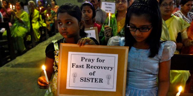 Girls hold a placard and candles during a special prayer service at a church to show solidarity with the nun who was raped during an armed assault on a convent school, in Kolkata March 17, 2015. Indian Prime Minister Narendra Modi said on Tuesday he was