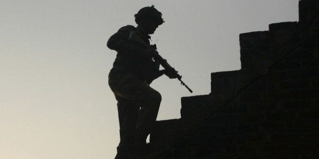 An Indian army soldier climbs up stairs to take his position on the rooftop of a residential house outside the Indian Air Force (IAF) base at Pathankot in Punjab, India, January 3, 2016. Indian security forces battled into Sunday evening to secure an air base near the border with Pakistan, a day after a militant attack that has killed seven military personnel and wounded another 20. REUTERS/Mukesh Gupta
